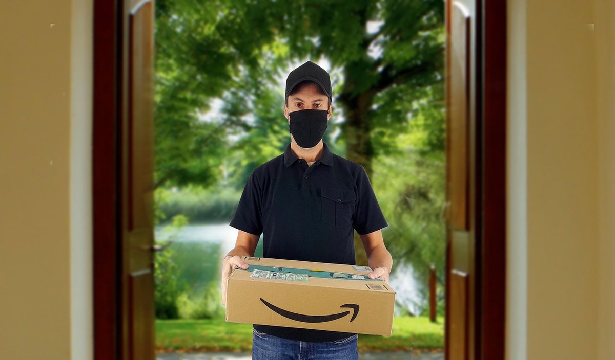 Homme en noir devant une porte, livrant un colis Amazon, nature en arrière-plan Homme en noir devant une porte, livrant un colis Amazon, nature en arrière-plan