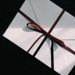 Enveloppe blanche nouée avec un ruban marron sur fond noir