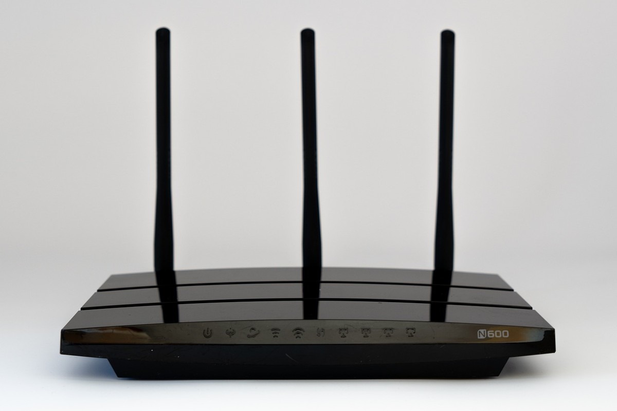 Un routeur noir à trois antennes posé sur fond blanc Un routeur noir à trois antennes posé sur fond blanc