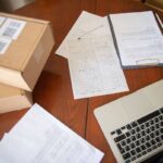 Ordinateur portable, documents et boîtes sur une table en bois