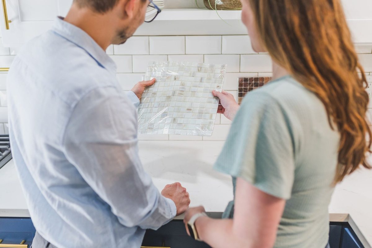 Homme et femme analysent un plan sur une table dans une cuisine Homme et femme analysent un plan sur une table dans une cuisine