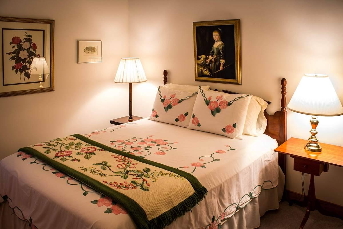 Chambre d'hôte décorée avec lits douillets, lampes de chevet allumées, tableaux muraux Chambre d'hôte décorée avec lits douillets, lampes de chevet allumées, tableaux muraux