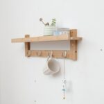 Étagère en bois fixée au mur, pot avec plante, tasse accrochée
