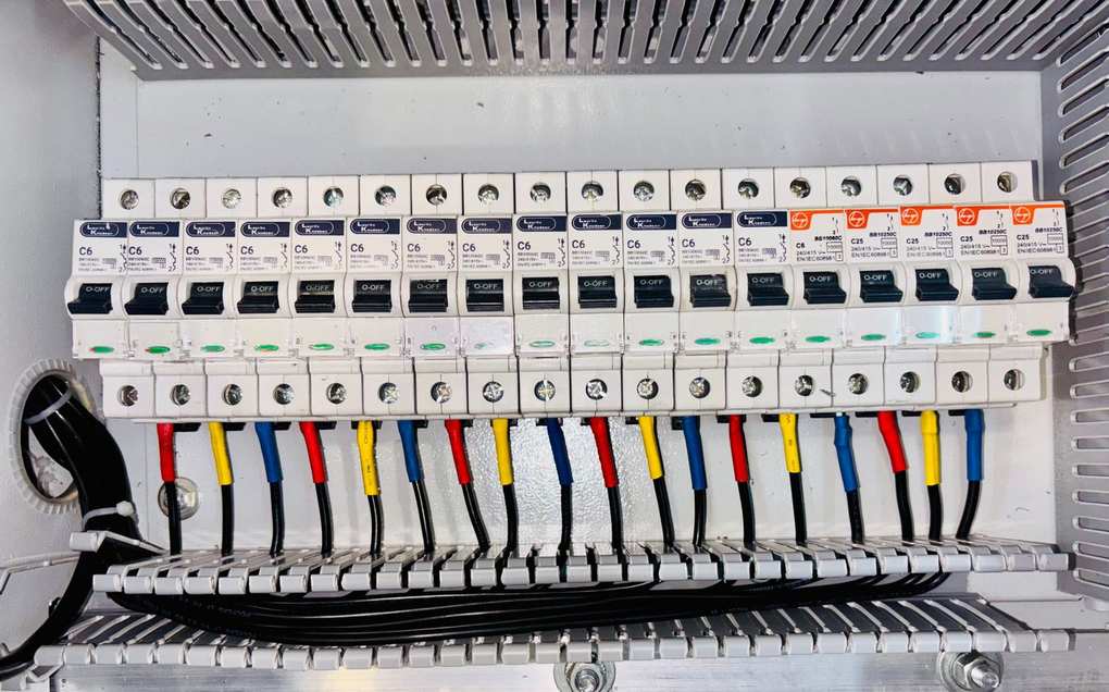 Disjoncteurs et câbles colorés dans un tableau électrique Disjoncteurs et câbles colorés dans un tableau électrique