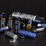 Batteries de diverses marques et une torche sur fond noir