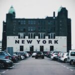 Une allée de parking bordée de voitures devant l'hôtel New York