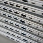 Empilement d'ordinateurs portables montrant leurs ports sur une surface blanche